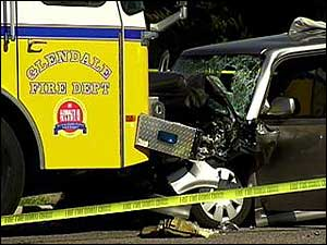 The fire truck, with its lights flashing, was parked in a curb lane in front of a house.