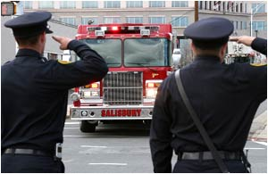 Public saPublic safety officials salute a Salibury fire truck as it escorts the bodies of fallen firefighters Vistor Isler and Justin Monroe to the medical examiners office on March 8.