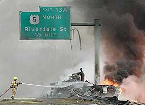 A firefighter works at the scene of an accident involving a fuel tanker truck that left the roadway and caught fire after a crash on Interstate 91, March 28.