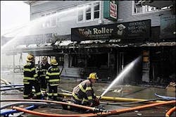 Firefighters train their hoses on a Dough Roller restaurant. Firefighters train their hoses on a Dough Roller restaurant.
