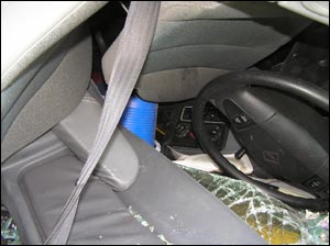This view shows inside the truck's cab, and the problems that you could anticipate with an 18-wheeler rollover and a trapped driver. Remember, with a sleeper cab, there could be multiple occupants trapped. Note the crushing that has occurred and the steering wheel is down into the windshield. The roof is crushed, the seats are bent and folded. Even the seatbelt would potentially have to be dealt with to free a trapped driver. In many situations like this, the driver remains inverted and trapped in position.