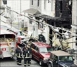 Firefighters and crime-scene investigators combed through the scene at 154 West 6th St. after a fire ripped through the three-decker home, April 6.