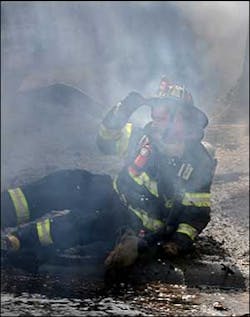 A firefighter is knocked to the ground during a blaze on Central Street in Saugus yesterday.