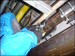 A hazmat team member clamps a simulated leak from a pipe in the fire station.