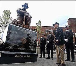 Retired Brockton fire Chief Edward Burrell, 93, views the new monument, topped by his likeness, to the fallen heroes of the Strand Theatre fire.