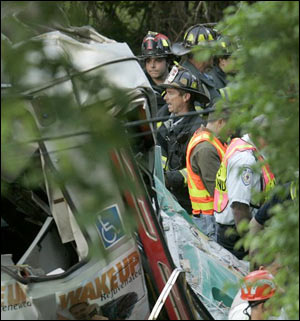 Emergency rescue workers and firefighters work at the scene of a train collision, in Newton, Mass.