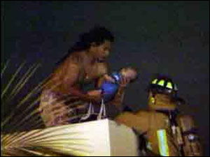 The father jumped to a neighboring building, with an infant in his arms, and waited to be rescued by firefighters.