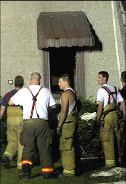 Firefighters at the scene of a house fire in Forrest react to events that occurred during the course of fighting the fire, Tuesday, July 22, 2008.