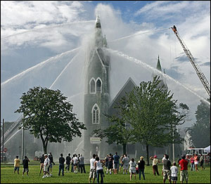 People gather on Lynn Common to watch firefighters battle a blaze at the historic First Baptist Church.