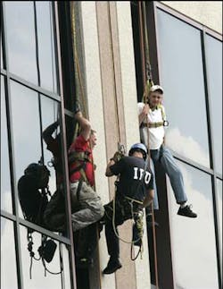 An Indianapolis firefighter reaches two of three men dangling from ropes about 15 stories high on a downtown Indianapolis building after the scaffolding the men were using collapsed. An Indianapolis firefighter reaches two of three men dangling from ropes about 15 stories high on a downtown Indianapolis building after the scaffolding the men were using collapsed.