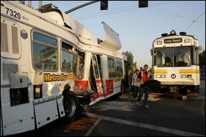 Emergency responders walk between the wreckage after a Metro Blue Line train collided with an out-of-service bus near downtown Los Angeles, Sept. 19.