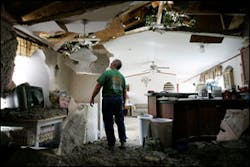 Labelle-Fannett volunteer firefighter Fred Bridgewater looks up at the damage to his house's roof caused by a fallen tree due to high winds from Hurricane Ike. Labelle-Fannett volunteer firefighter Fred Bridgewater looks up at the damage to his house's roof caused by a fallen tree due to high winds from Hurricane Ike.