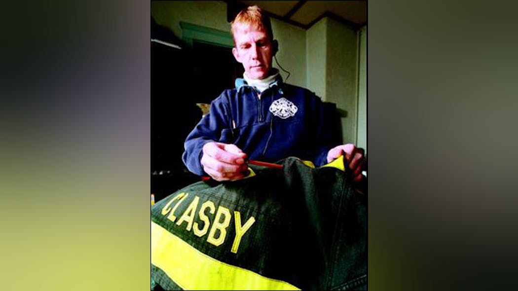 Former Hull firefighter John Clasby uses a pencil to indicate a hole in his firefighter&apos;s jacket where a bullet pierced through and severed his spinal cord while he was fighting a fire in June 1999.