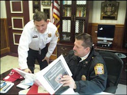 Chief Dennis Rubin, seated, goes over a section in the response plan with Billy Hayes, director of public information. Chief Dennis Rubin, seated, goes over a section in the response plan with Billy Hayes, director of public information.
