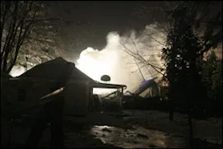 Firefighters spray and foam at the scene where a plane crashed into a house and burned in Clarence Center, N.Y. Firefighters spray and foam at the scene where a plane crashed into a house and burned in Clarence Center, N.Y.