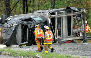 Firefighters examine the wreckage of a Bradley-Prosperity Volunteer Fire Department rescue truck after it crashed Tuesday while traveling on the West Virginia Turnpike.