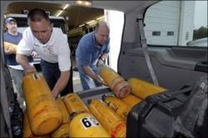 Rollinsford Fire Chief Mike Spinney and Sean Donnelly of Missionary Air Group load a van full of used firefighting equipment for a department at Mundo Maya International Airport in Guatemala.