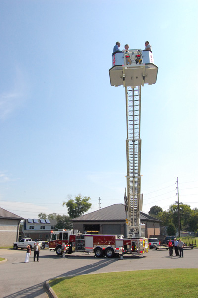 The four men get a bird's eye view of the new fire truck's firefighting and rescue capabilities.