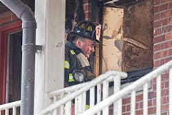 A firefighter looks into the window of the fire damaged apartment in the P.T. Barnum complex in Bridgeport, Conn., Friday, Nov. 13, 2009. A firefighter looks into the window of the fire damaged apartment in the P.T. Barnum complex in Bridgeport, Conn., Friday, Nov. 13, 2009.