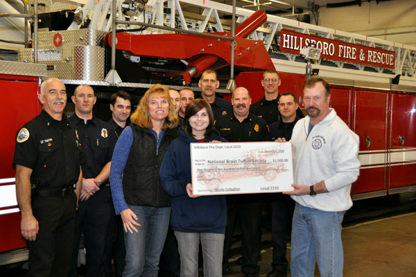 Retired firefighter Frank Reimers (r) and Nicole Callahan (holding check) with her mother Karla and a check to the National Brain Tumor Society.