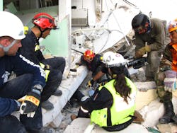 Paramedic Greg Tabeek, left, and Spanish USAR team member Matias Monedo, top left, prepare to swap out with Lt. Beardsley, who&apos;s coming out from underneath the hospital.