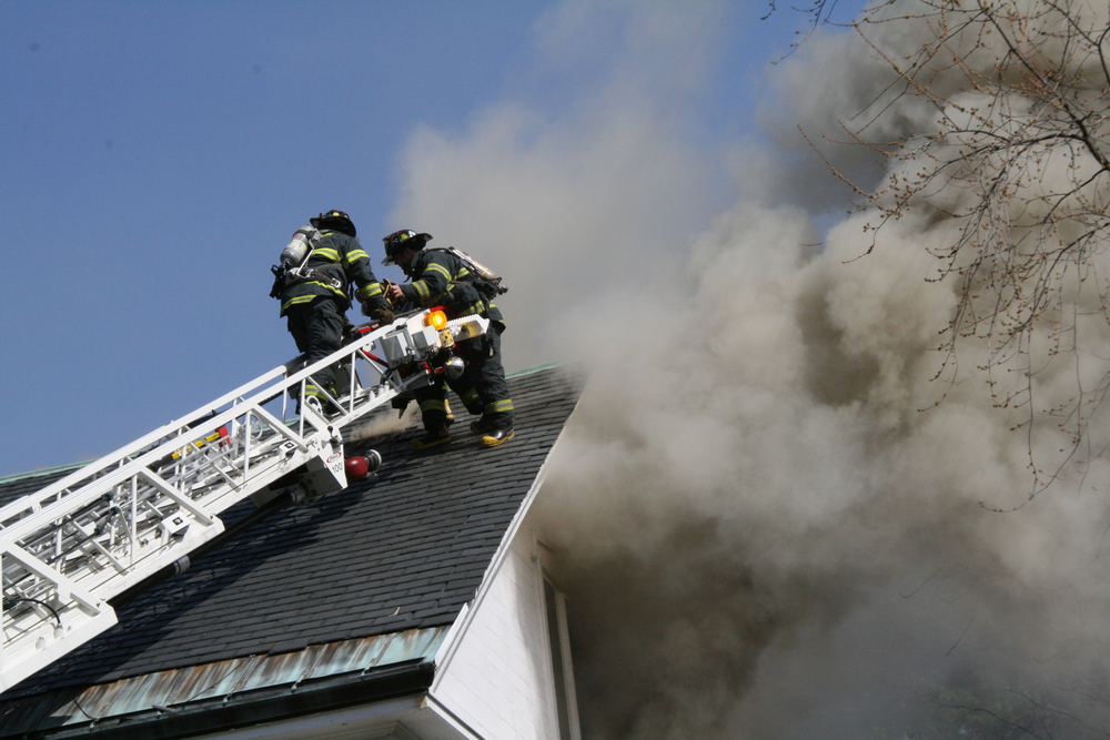 Firefighter's work to ventilate the roof of the structure.