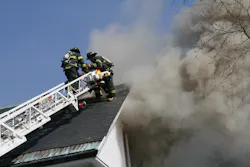 Firefighter's work to ventilate the roof of the structure.