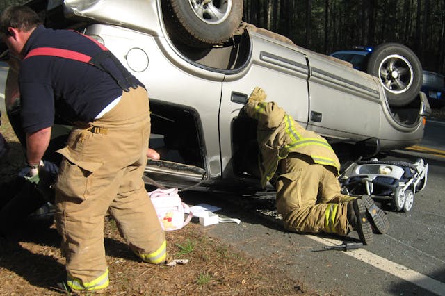 Pine Mountain firefighter JR Owens (left) and Fire Chief Tim Edgar maneuver in and around the wreckage of James Gunder&rsquo;s Chevrolet Blazer, offering help to the occupants.