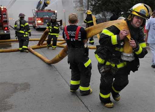 Firefighters lay a hose while battling the blaze.