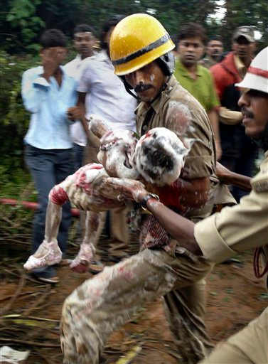 Indian firefighters carry a child, reportedly a survivor, out of the debris.