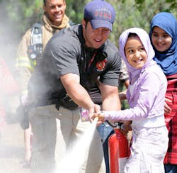 Capt. Brian Siccone, Fire and rescue technician, shows an Iraqi Girl Scout the proper way to use a fire extinguisher in Baghdad on May 2.