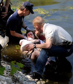 Piqua firefighter Bill Hogston and detective Dave Thomas help support an injured student. Piqua firefighter Bill Hogston and detective Dave Thomas help support an injured student.