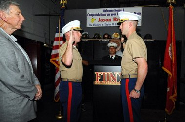 Firefighter Jason Brezler, right, takes the Oath of Office, promoting him to Major in the U.S. Marine Corps.