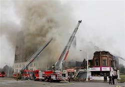 Detroit firefighters battle a burning two-story partially collapsed building with aerial units.