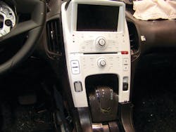 This Chevrolet VOLT has been used for extrication training as part of a program presented by Chevrolet and ONSTAR. On the left side of the VOLT center console is the grayish-color &ldquo;START/STOP&rdquo; button. The gear selector lever is the large device in the center. The electric parking brake is the white button to the right of the gear selector.