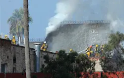 Los Angeles firefighters work to contain a fire that burned through the roof of a six-story apartment building. Los Angeles firefighters work to contain a fire that burned through the roof of a six-story apartment building.