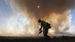 A Silver City hotshot starts a backfire along a rural road in Roger's Canyon, 10 miles northeast of Laramie, Wyo. A Silver City hotshot starts a backfire along a rural road in Roger's Canyon, 10 miles northeast of Laramie, Wyo.