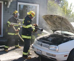 A month before a firefighter was photographed fighting a car fire without proper equipment, firefighters extinguished a car fire without proper gear.