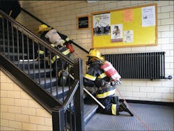 Rapid intervention team members, with masks obscured to simulate smoke conditions, begin the simulated search and lost firefighter. Rapid intervention team members, with masks obscured to simulate smoke conditions, begin the simulated search and lost firefighter.