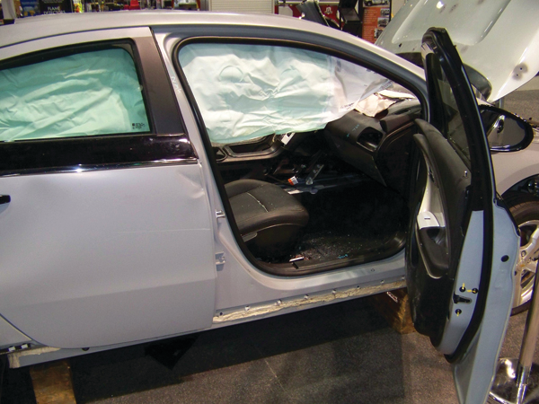 The four doors on the Chevrolet VOLT have conventional hinge and latch assemblies, a high-strength collision beam inside, and tempered-glass safety windows. Note how the deployed roof airbag obstructs patient access. The bag can be cut away by responders on scene.