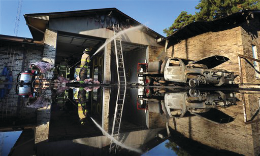 Firefighters work on hot spots at the Caddo Parish Fire District 1 after a grass truck caught fire and the fire moved into the building.