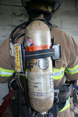 Photo 1: The rope should be wrapped behind the back, around the SCBA, as high under the arms as possible. Both ends should be in front of the body.