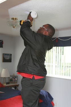An employee installs a smoke alarm during what was the fire district's largest one day installation effort ever. An employee installs a smoke alarm during what was the fire district's largest one day installation effort ever.