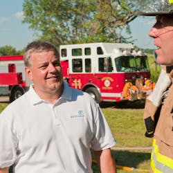 Doug Ruth, EarthClean Corporation founder and CEO (left) talks with firefighter Terry Lund after a live burn exercise.