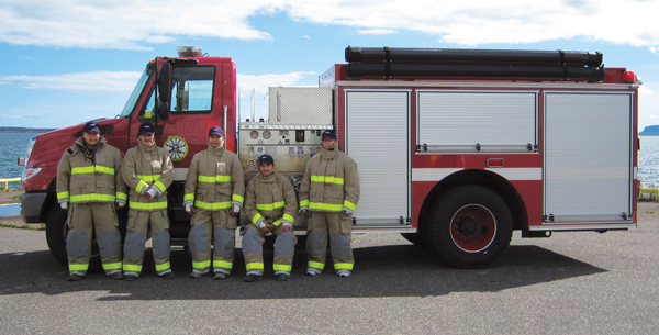 Firefighters from Sandy Lake First Nation stand alongside their new Pierce&circledR; pumper that will be shipped to their community via ice roads over various lakes in February 2011.