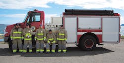 Firefighters from Sandy Lake First Nation stand alongside their new Pierce&circledR; pumper that will be shipped to their community via ice roads over various lakes in February 2011.