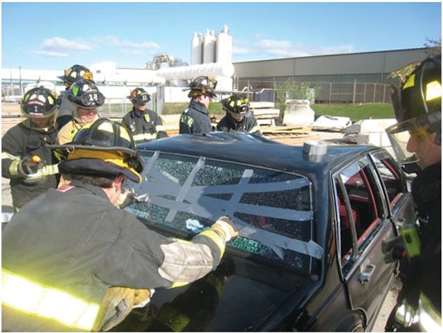 Photo 1. Rescuers use duct tape to provide some cohesion to the tempered glass so it can be removed collectively.