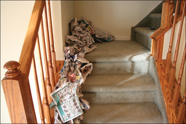 Newspaper is used to create a trailer on the stairs of a dwelling in this training prop. The trailer will move the fire from the first floor to second floor landing.