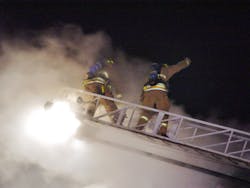 Firefighters on an aerial ladder vent the church roof as steam (not smoke) from TetraKO&apos;s defensive fire attack escapes. The church building, and much of its contents are saved, with minimal water damage