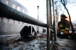 Ice forms on scaffolding as a member of the Toronto Fire Department battles a blaze in Toronto that disrupted transit service and closed Ryerson University.